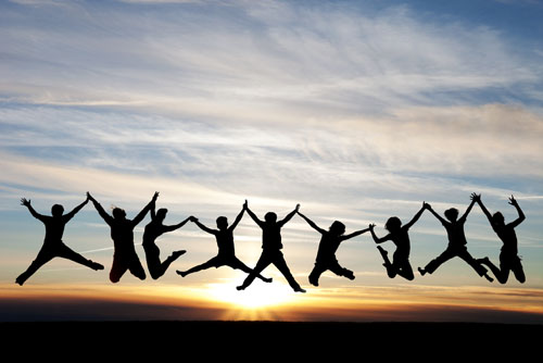 people jumping in the air in front of a sunset